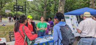 DOT staff talk with community members about the Harlem River Greenway planning process while tabling at a park in the Bronx.